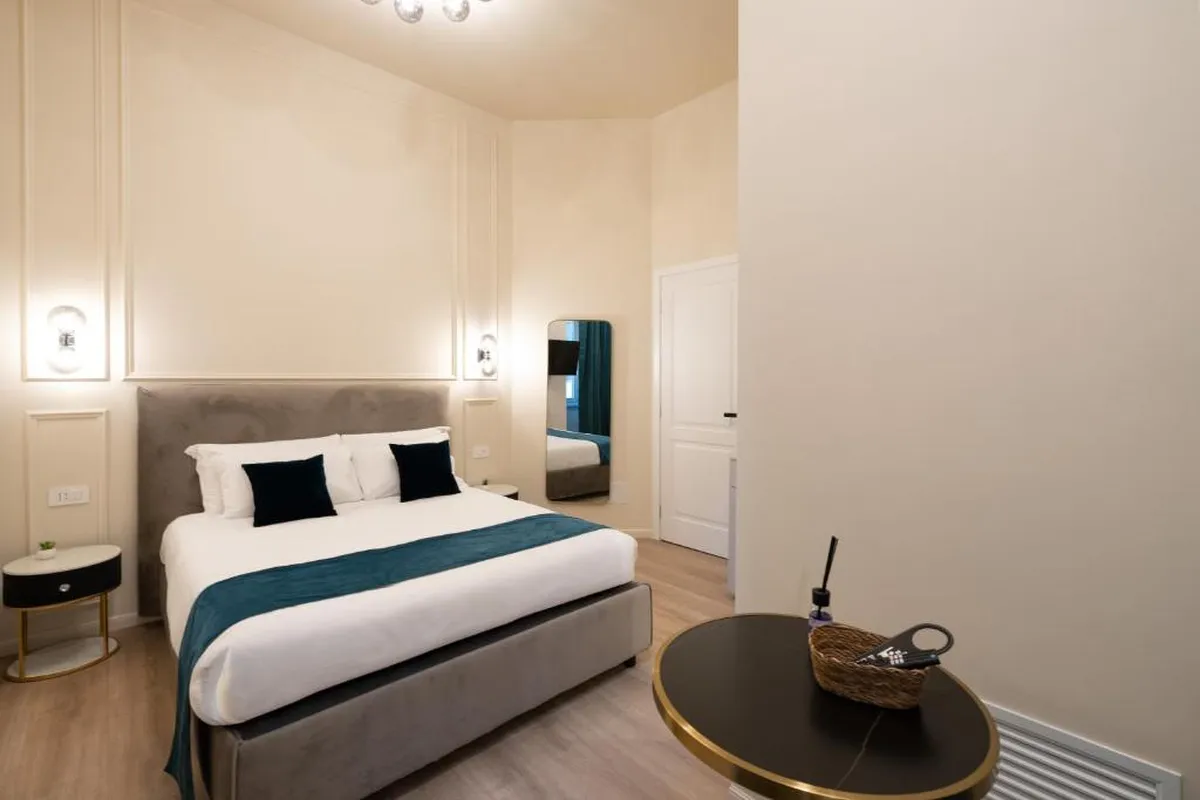 Camera dell'affittacamere all'Esquilino aperto da ReRent Group a gennaio 2026: letto matrimoniale, testiera imbottita e tavolino tondo