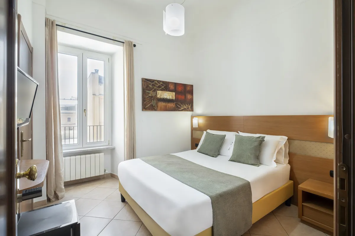 Una camera dello stesso hotel con ReRent Group: letto matrimoniale con biancheria bianca e cuscini verdi