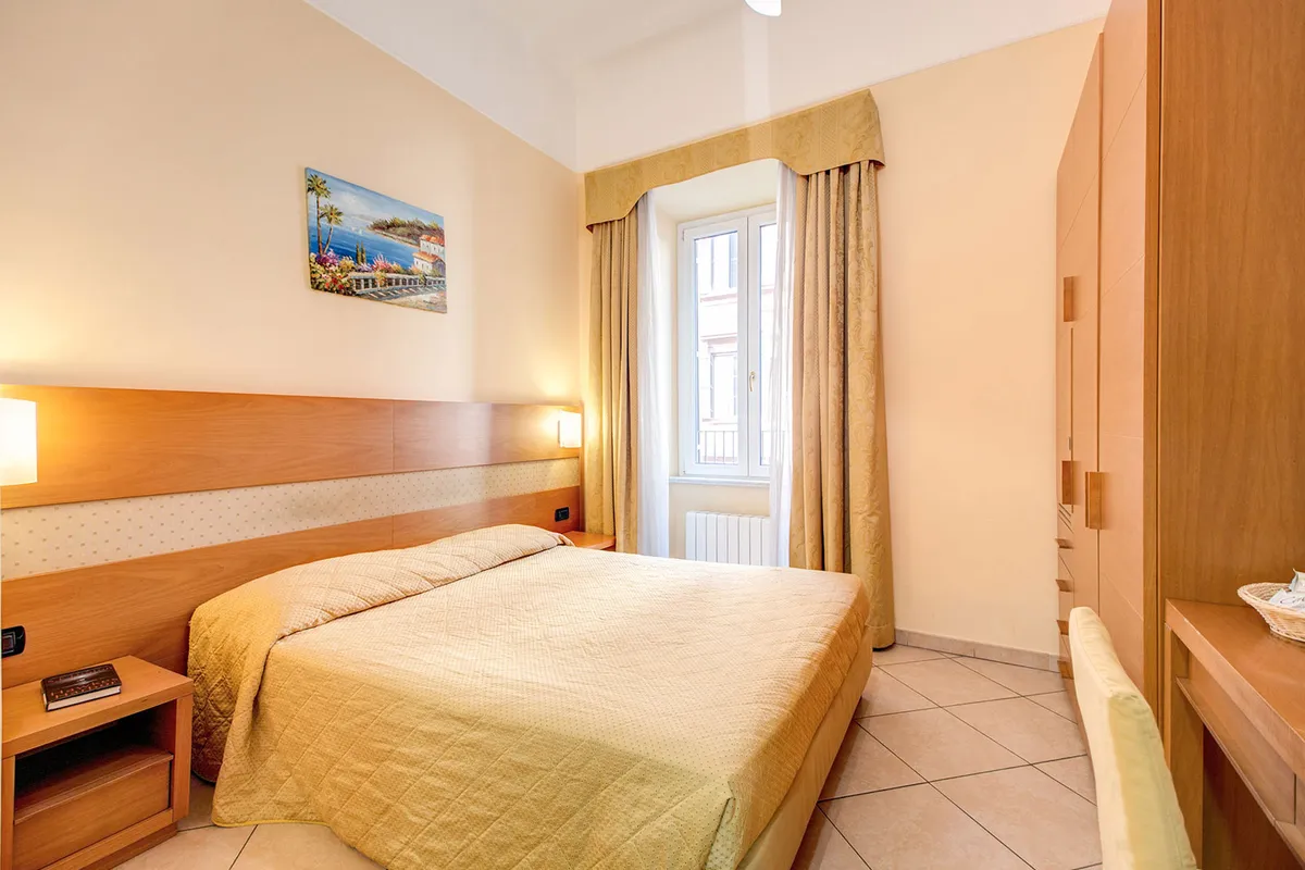 La camera dell'hotel all'Esquilino prima della nostra gestione: copriletto dorato e tende dorate