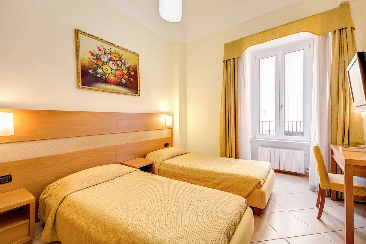Un'altra camera dell'hotel all'Esquilino prima della nostra gestione: due letti singoli con il copriletto dorato